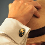 Map of the world cufflinks in bronze and blue green patina on a man putting on a panama hat
