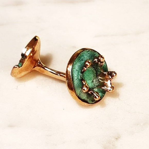 Round cufflink in the form of a water splash in bronze with blue green patina